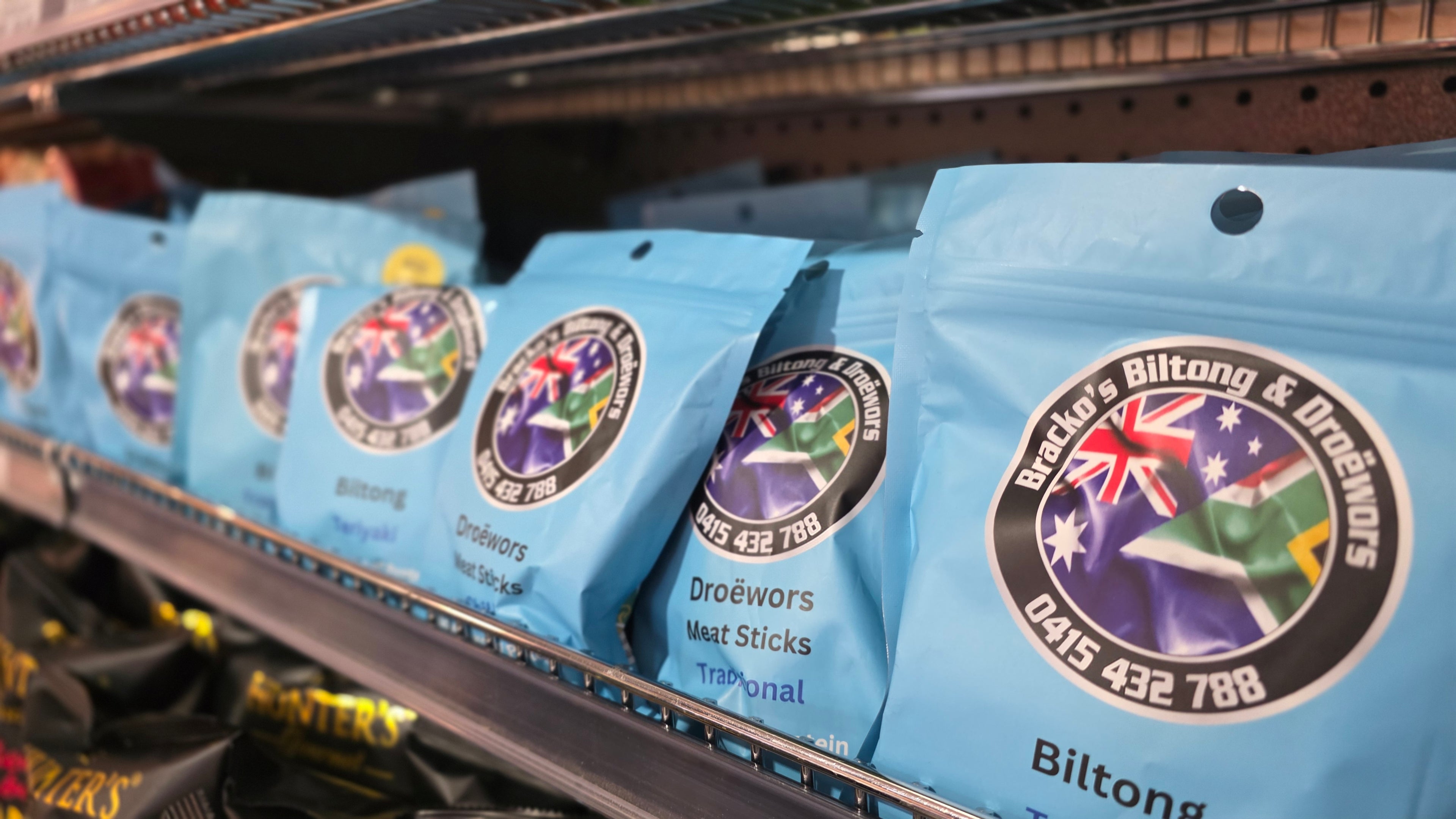 Biltong packages on a shelf with visible branding and product details.
